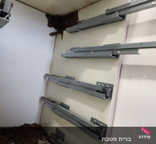 מסילות מתכת בארון מטבח עם נזקי רטיבות